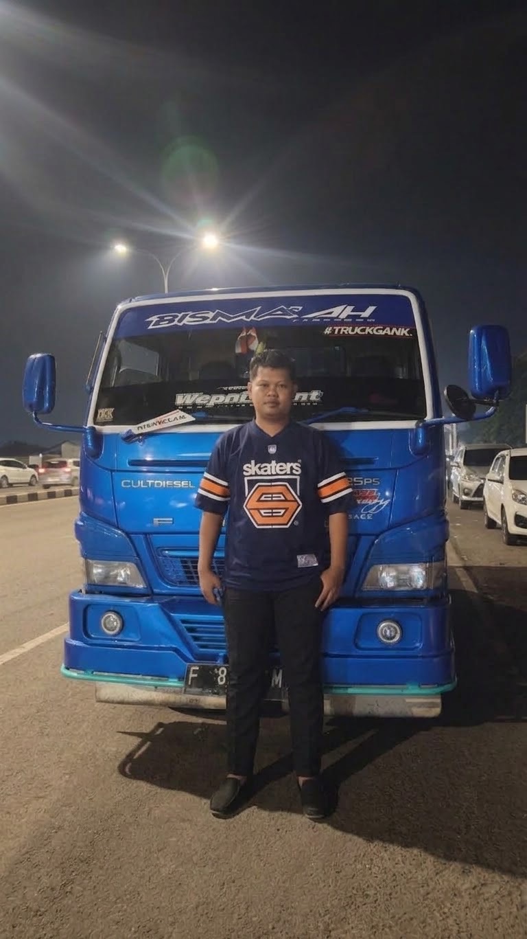 Sopir armada MFB berdiri di depan truk tangki pada malam hari